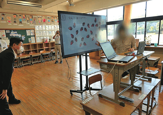 水戸市長高橋やすしが教室でデジタル黒板を見ている写真